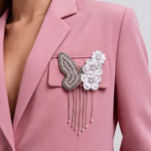 Exquisito accesorio de prenda con mariposa floral de pedrería brillante detalle.
