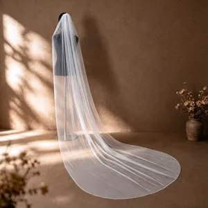 Vista dettagliata del lungo velo da sposa con bordo perlato cucito a mano su tulle trasparente.