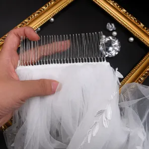 Bruids huwelijk sluiter met metalen kam en delicate bladeren kant borduurwerk, elegante witte tule.