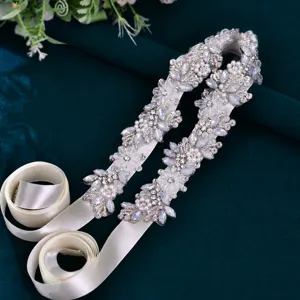 Bridal rhinestone belt detail, sparkling crystal floral appliques on white satin ribbon.