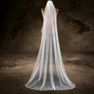 White bridal veil with beaded lace edge, church cathedral length for wedding ceremony.