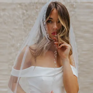 Elegant bridal veil with exquisite beaded lace trim, perfect for wedding ceremonies and dresses.