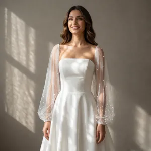 Detailed view of elegant white sheer tulle bishop sleeves adorned with delicate pearls for bridal gowns.
