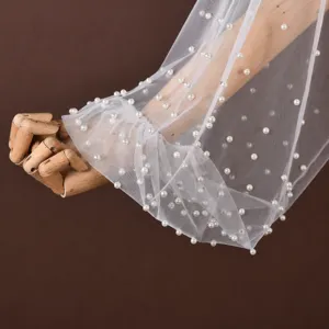 Elegant white sheer mesh arm sleeves with scattered pearls, detailed closeup view for fashion.