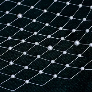 White pearl mesh veil detail for bridal headpiece, elegant party hair accessory decoration.