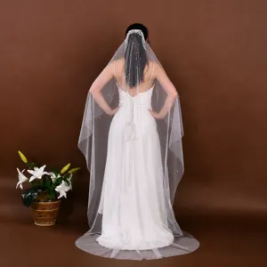 Cathedral wedding veil featuring delicate pearl embellishments and long flowing sheer tulle design.