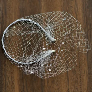 Vista di dettaglio dell'elegante cerchietto con velo da sposa bianco scintillante di strass per feste.