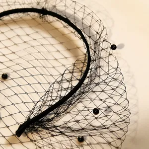 Primo piano dei dettagli della fascia per capelli nera in rete con perle eleganti.