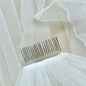 Détail de voile de mariée fait main avec peigne en métal et perles pour mariage et séance photo.
