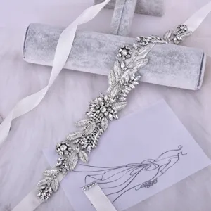Détail de la ceinture de mariée en strass avec broderie de perles de cristal sur ruban.