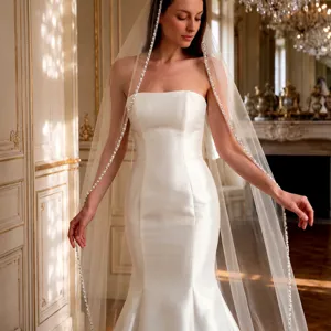 Vue détaillée d'un magnifique voile de mariée avec des perles cousues main dans un salon de luxe.