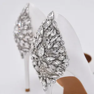 Detaillierte Nahaufnahme von Braut-High-Heels mit funkelnden Strasssteinen und Kristallperlen.