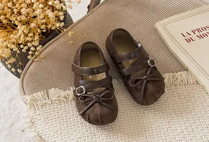 Detailansicht vintage brauner Kleinkind Mädchen Schuhe mit Schleife und den Riemchen.