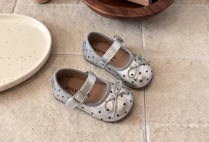 Detailed view of silver polka dot children mary jane shoes with bow and strap.