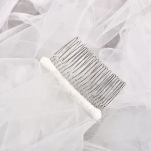 Bridal metal hair comb with white lace wrap on tulle background, elegant wedding hair accessory.