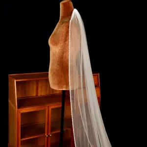 Voile de mariee blanc elegant avec bordure de perles fait main pour mariage somptueux.