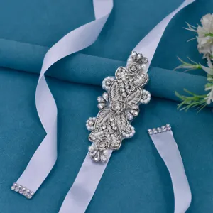 Vista dettagliata della cintura da sposa in strass con perle e ricamo metallico.