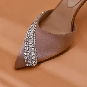 Close-up view of pointed-toe satin high heels adorned with sparkling rhinestone crystal straps.