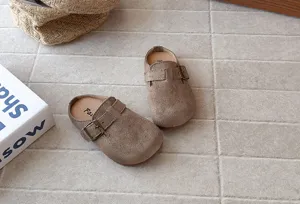Detailed shot of retro kids suede clogs with side buckle, soft sole slip-on design.