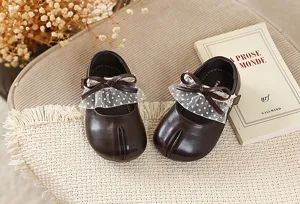 Zapatos planos marrones para niñas con lazo de encaje y suela suave y cómoda.