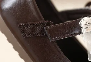 Primer plano del detalle de la correa del zapato infantil con velcro y lazo de encaje.