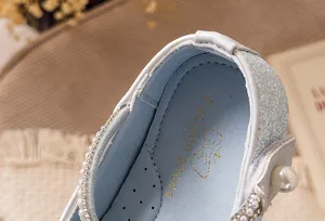 Nahaufnahme der inneren Einlegesohle mit glitzerndem Finish und zierlicher Schleife.