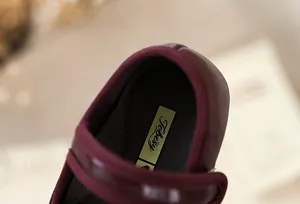 Detailopname van de binnenkant van de leren meisjes schoen met zichtbaar merklogo.