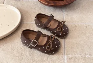 Brown polka dot toddler Mary Jane shoes featuring cute bow and metal buckle strap details.