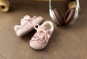 Bonitas zapatillas deportivas rosas para niños de ante con cordones de lazo, suaves y cómodas.