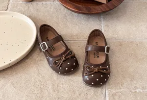 Detail view of brown toddler Mary Jane shoes with white polka dots and cute bow accent.