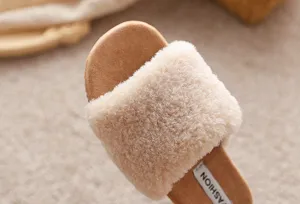 Gros plan détaillé de la sandale duveteuse dotée d'une lanière en peluche et semelle plate.