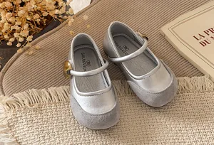 Detailed shot of silver children mary jane shoes with grey suede toe cap and metal buckle.