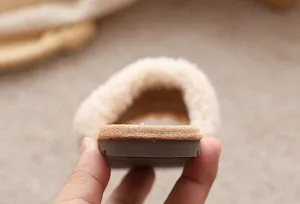 Vue détaillée de la semelle et de la doublure pelucheuse des pantoufles, texture confortable.