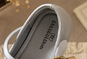 Detail shot of silver leather kids princess flats insole showing the interior brand logo print.