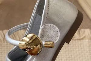 Kids silver leather shoes detail view, elegant princess style flat footwear with golden leaf ornament.
