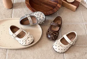 Detailed view of girls polka dot Mary Jane flat shoes, featuring cute bows and soft soles.