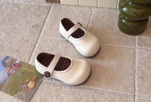 Detailaufnahme süßer Kleinkind Mary Jane flache Schuhe in Beige mit süßem Pünktchenfutter.