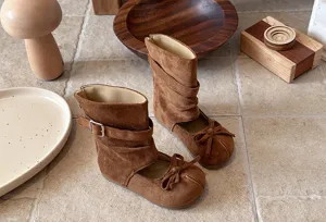 Details of brown suede girls cutout boots featuring bow decor and side buckle for chic spring style.