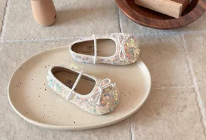 Détail de chaussures Mary Jane pailletées pour bébés, sequins brillants et joli nœud fille.