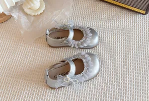 Vista dettagliata di scarpe Mary Jane argento per bambina con pizzo e fiocco di perle.