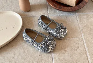 Gros plan detail chaussures plates Mary Jane sequin gris pour petite fille avec noeud.