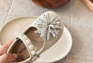 Close-up detail of girls princess shoes, showing rhinestone crystal flower and pearl strap.