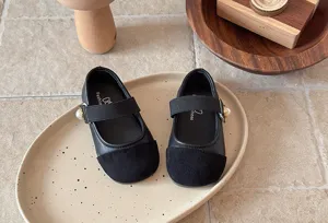 Détail de ballerines noires pour filles en bas âge avec détail perle et semelle souple.