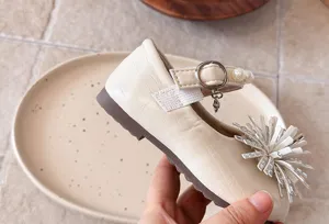 Close-up of toddler girls leather dress shoes with pearl strap and rhinestone fringe.