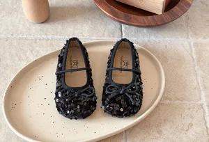 Vue détaillée de charmantes chaussures de princesse à paillettes noires pour petite fille.