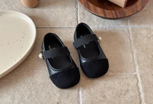Vue détaillée de chaussures Mary Jane en cuir noir pour enfants avec boutons perles.