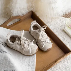 Chaussures de sport rétro à nœud pour enfants en beige avec semelles souples pour un usage quotidien.