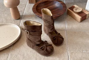 Brown suede mid-calf boots for girls featuring a cute bowknot cutout design and buckle.