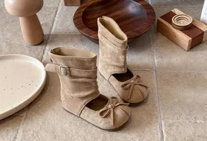 Girls suede mid-calf cutout boots with bow and buckle detail, retro style for spring.