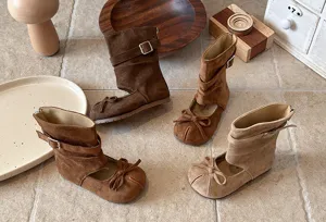 Kids brown suede mid boots with cutout bows and buckle straps, cute autumn fashion footwear.
